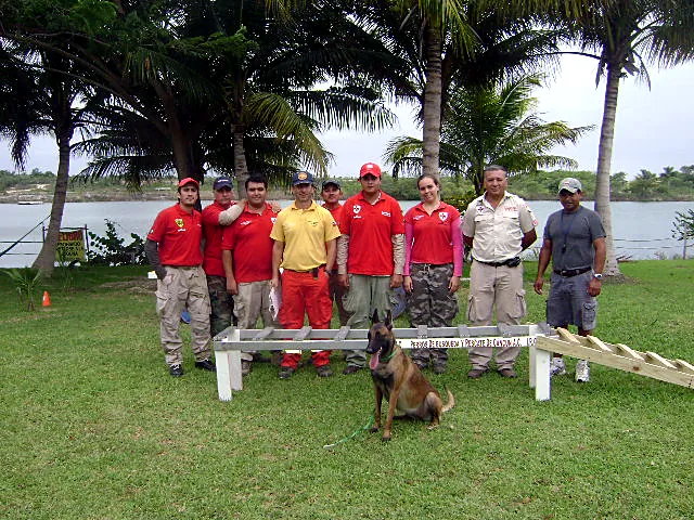 Rescatistas y un pastor belga malinois en el campo de entrenamiento de Perros de Búsqueda y Rescate de Cancún.