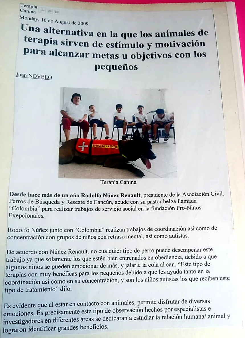 Recorte de prensa de 2009 sobre terapia canina con niños, con foto de un malinois con chaleco de rescate